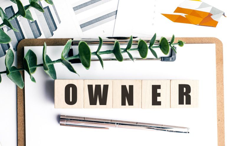 Owner-operated business executive search, wooden blocks spelling owner on clipboard with financial charts, Michigan retained search firm