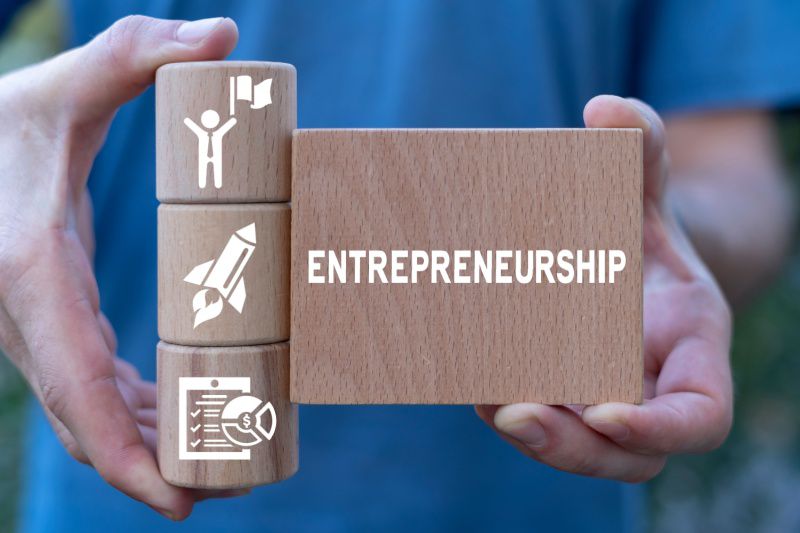 Entrepreneurial business executive search, entrepreneur holding wooden blocks spelling entrepreneurship, representing retained executive search for entrepreneurial companies in Michigan